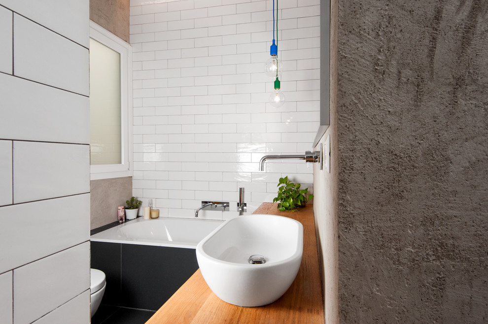 Пример оригинального дизайна: ванная комната в современном стиле с черно-белой плиткой, керамогранитной плиткой, настольной раковиной и столешницей из дерева