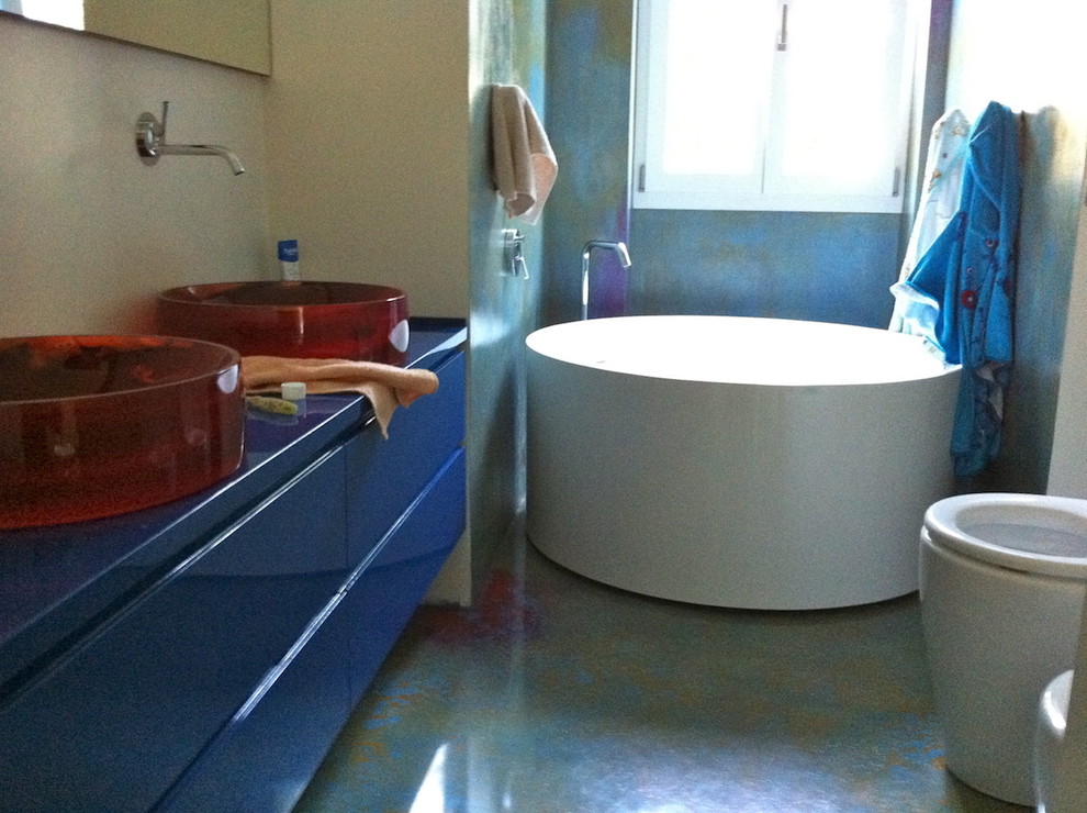 Mittelgroßes Modernes Kinderbad mit blauen Schränken, freistehender Badewanne, Unterbauwaschbecken und Waschtisch aus Holz in Mailand