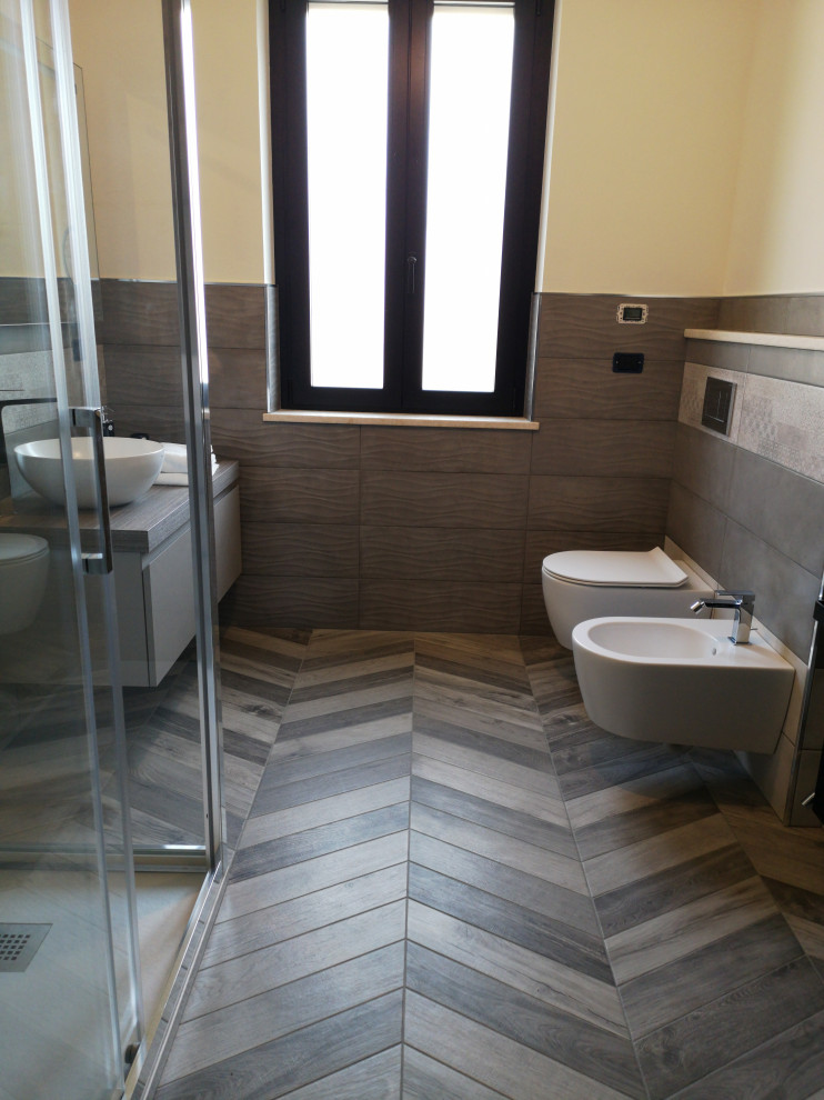 Diseño de cuarto de baño principal minimalista de tamaño medio con sanitario de pared, baldosas y/o azulejos de porcelana, suelo de baldosas de porcelana, lavabo sobreencimera, encimera de laminado, suelo gris y encimeras grises