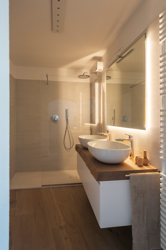 На фото: ванная комната в современном стиле с душем без бортиков, белой плиткой, керамогранитной плиткой, серыми стенами, светлым паркетным полом, настольной раковиной, коричневым полом и открытым душем с