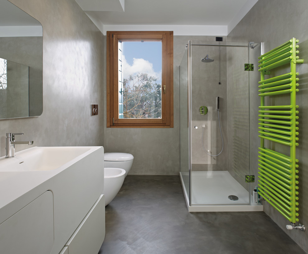 Cette image montre une salle de bain design avec une douche d'angle, sol en béton ciré et un lavabo intégré.