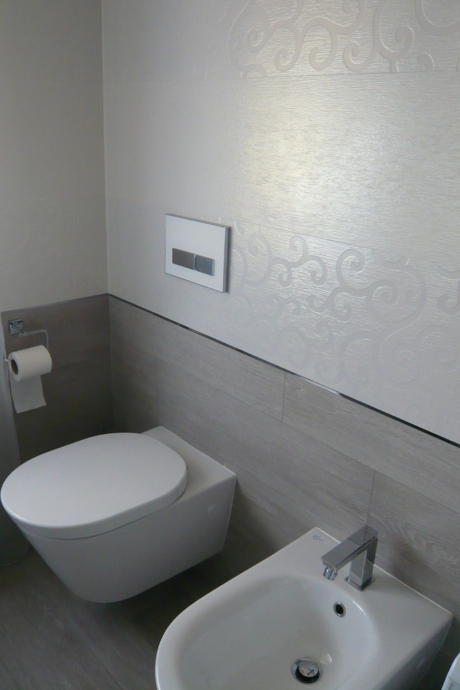 Foto di una stanza da bagno moderna con vasca/doccia, WC sospeso, piastrelle in ceramica, pareti multicolore, pavimento in gres porcellanato e lavabo a bacinella