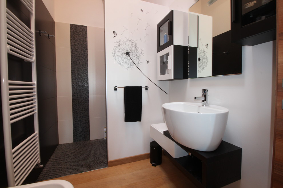 Immagine di una stanza da bagno con doccia design di medie dimensioni con ante di vetro, ante bianche, doccia a filo pavimento, WC a due pezzi, pistrelle in bianco e nero, piastrelle in gres porcellanato, pareti bianche, parquet chiaro, lavabo a bacinella, top in legno, pavimento marrone, doccia aperta e top nero