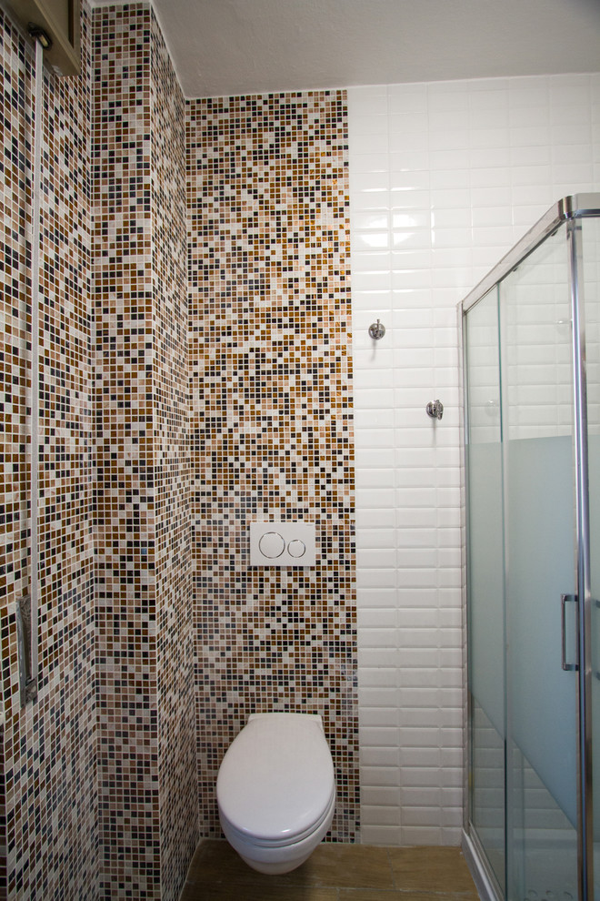 Exempel på ett litet modernt vit vitt badrum med dusch, med släta luckor, vita skåp, en vägghängd toalettstol, brun kakel, mosaik, klinkergolv i keramik, ett fristående handfat och brunt golv