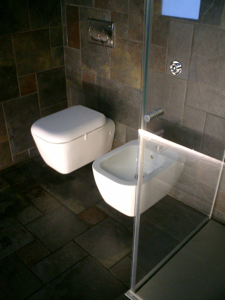 Источник вдохновения для домашнего уюта: ванная комната среднего размера в стиле модернизм с плоскими фасадами, серыми фасадами, душем без бортиков, инсталляцией, серой плиткой, керамогранитной плиткой, серыми стенами, полом из керамогранита, душевой кабиной, настольной раковиной и столешницей из нержавеющей стали