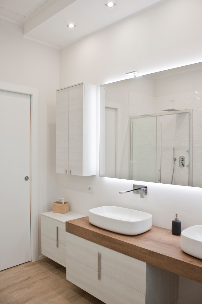 Design ideas for a medium sized contemporary family bathroom in Milan with flat-panel cabinets, light wood cabinets, white walls, porcelain flooring, a vessel sink, wooden worktops, beige floors, beige worktops, double sinks and a floating vanity unit.