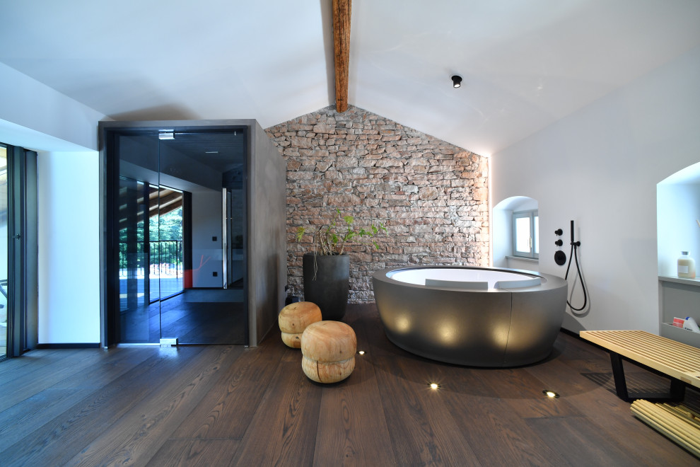 Aménagement d'une salle de bain contemporaine avec une baignoire indépendante, un mur blanc, parquet foncé et un sol marron.