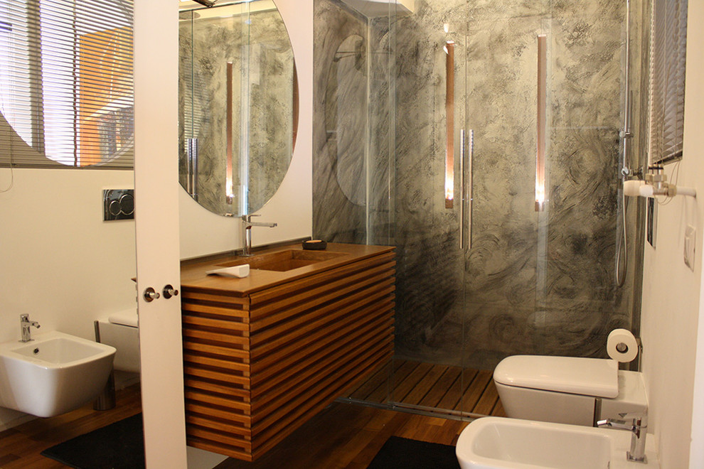 Bild på ett litet funkis badrum med dusch, med skåp i mellenmörkt trä, en kantlös dusch, en toalettstol med separat cisternkåpa, vita väggar, mellanmörkt trägolv, ett integrerad handfat, bänkskiva i koppar, brunt golv och dusch med skjutdörr