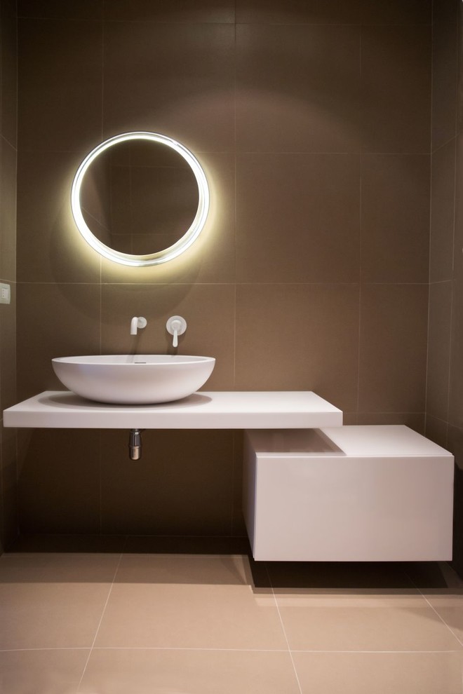Стильный дизайн: ванная комната среднего размера в современном стиле с плоскими фасадами, белыми фасадами, коричневой плиткой, керамической плиткой, полом из керамогранита, настольной раковиной и столешницей из искусственного камня - последний тренд