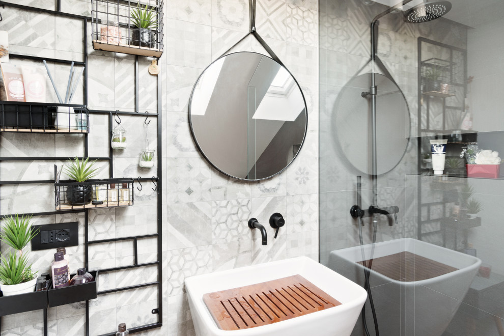 Foto di una stanza da bagno design con piastrelle grigie e lavabo sospeso