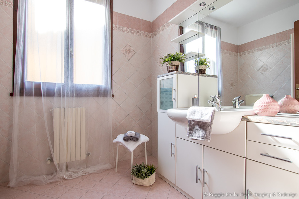Inspiration för ett mellanstort funkis badrum med dusch, med släta luckor, en hörndusch, en toalettstol med separat cisternkåpa, rosa kakel, porslinskakel, rosa väggar, klinkergolv i porslin, ett nedsänkt handfat, rosa golv och dusch med gångjärnsdörr