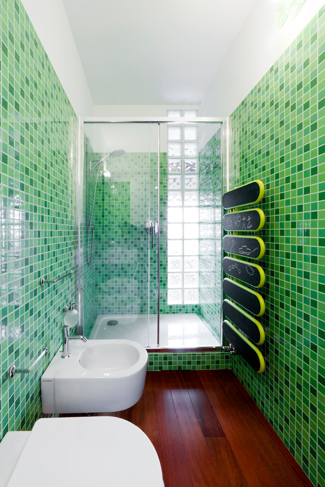 Foto de cuarto de baño infantil actual de tamaño medio con ducha empotrada, bidé, baldosas y/o azulejos verdes, baldosas y/o azulejos en mosaico, suelo de madera oscura y suelo marrón