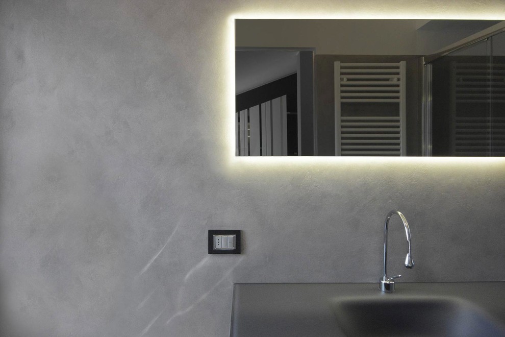 Ispirazione per una stanza da bagno con doccia design di medie dimensioni con ante di vetro, ante grigie, doccia doppia, WC a due pezzi, piastrelle grigie, pareti grigie, pavimento in cemento, lavabo integrato e top in vetro