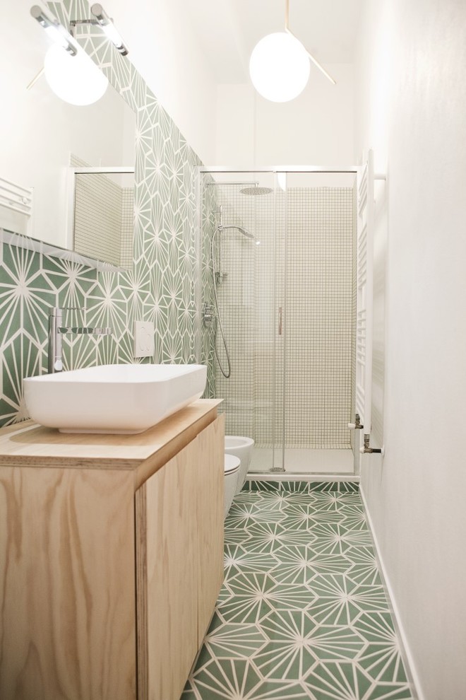 Inredning av ett nordiskt litet beige beige en-suite badrum, med skåp i ljust trä, ett hörnbadkar, grön kakel, vit kakel, cementkakel, gröna väggar, cementgolv, ett fristående handfat, träbänkskiva, grönt golv, dusch med gångjärnsdörr och släta luckor