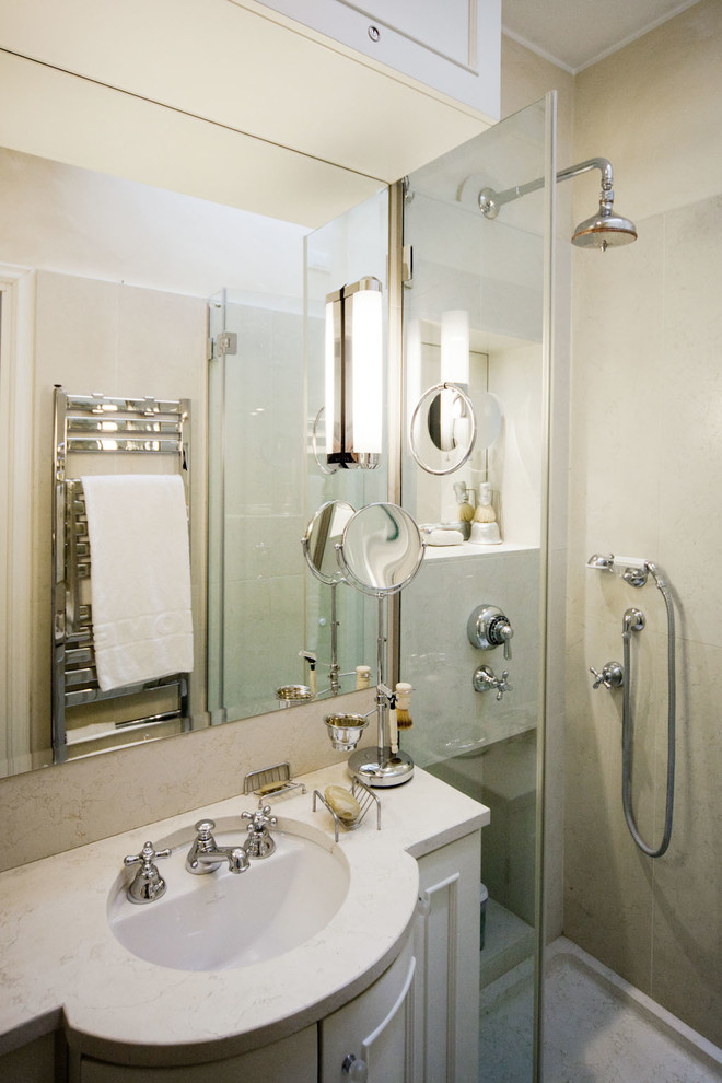 Inredning av ett klassiskt badrum med dusch, med beige skåp, stenhäll, beige väggar, ett undermonterad handfat, en hörndusch och luckor med infälld panel