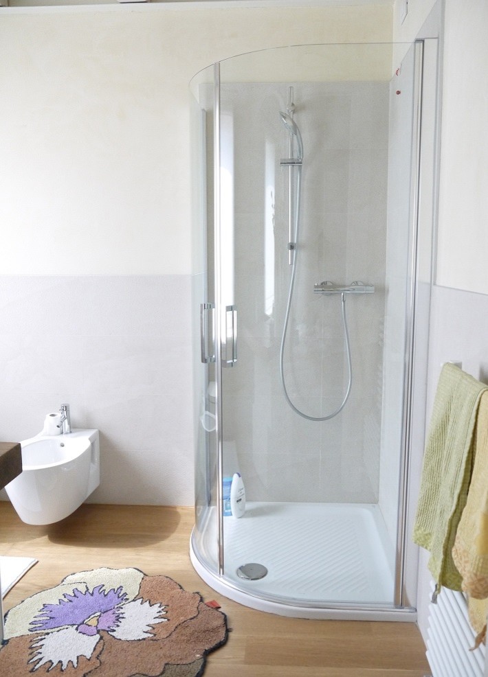Ispirazione per una piccola stanza da bagno design con ante di vetro, piastrelle beige, pareti beige, pavimento in legno massello medio, lavabo rettangolare e pavimento marrone