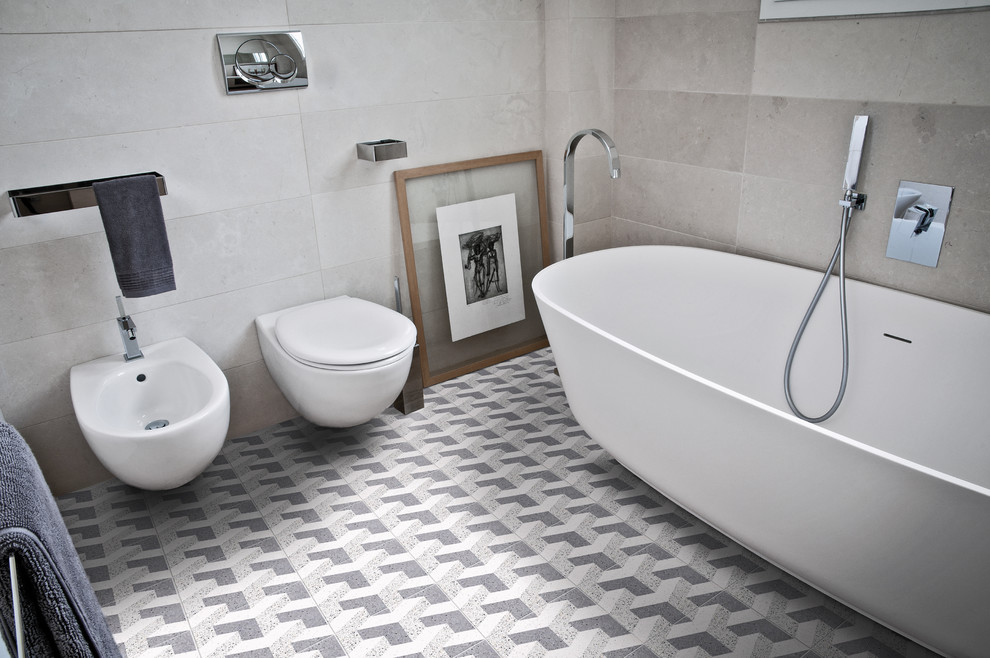 Cette photo montre une salle de bain principale tendance de taille moyenne avec une baignoire d'angle, WC séparés, un carrelage gris, des carreaux de céramique, un mur gris et un sol en marbre.