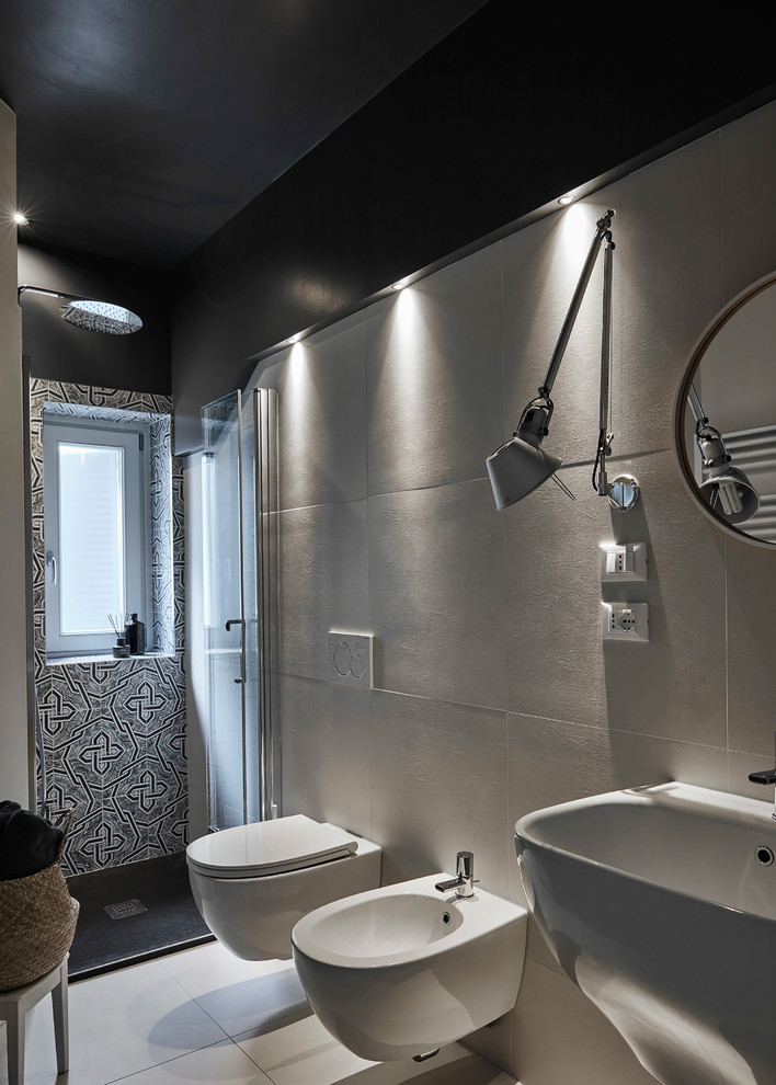 Modern inredning av ett mellanstort badrum med dusch, med en dusch i en alkov, en vägghängd toalettstol, svart och vit kakel, porslinskakel, svarta väggar, klinkergolv i porslin, ett väggmonterat handfat, vitt golv och dusch med gångjärnsdörr