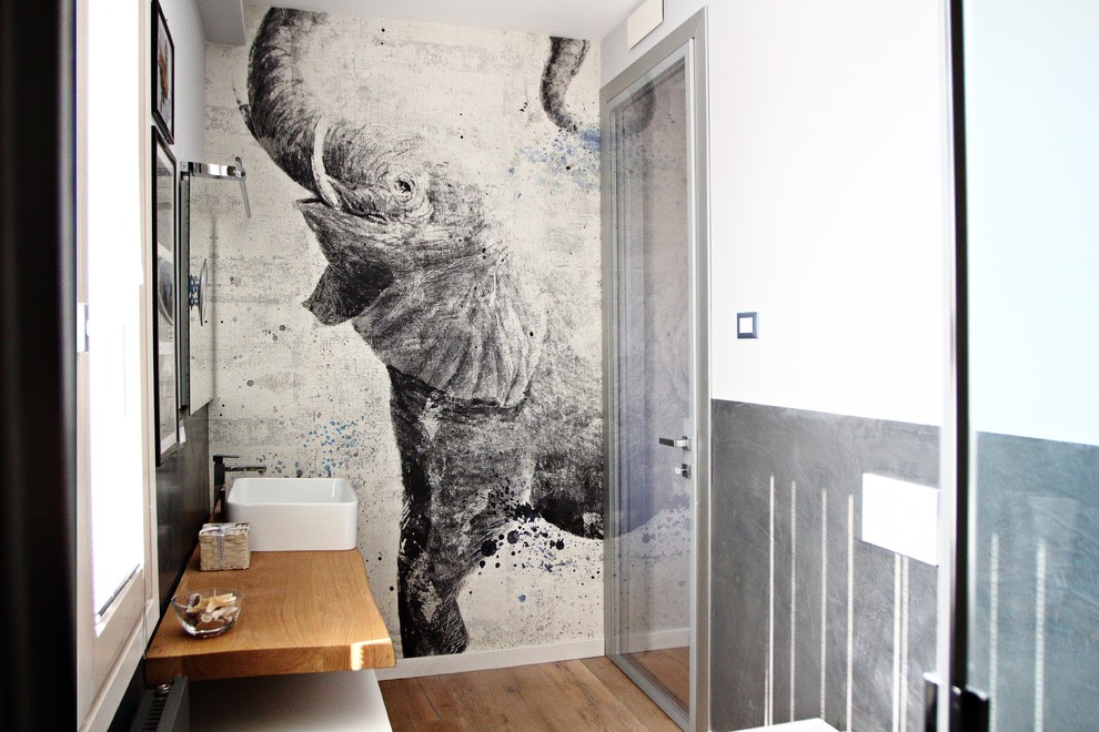 Inspiration pour une salle d'eau design en bois clair de taille moyenne avec un placard sans porte, une douche à l'italienne, WC suspendus, un mur gris, parquet clair, une vasque, un plan de toilette en bois et une cabine de douche à porte coulissante.