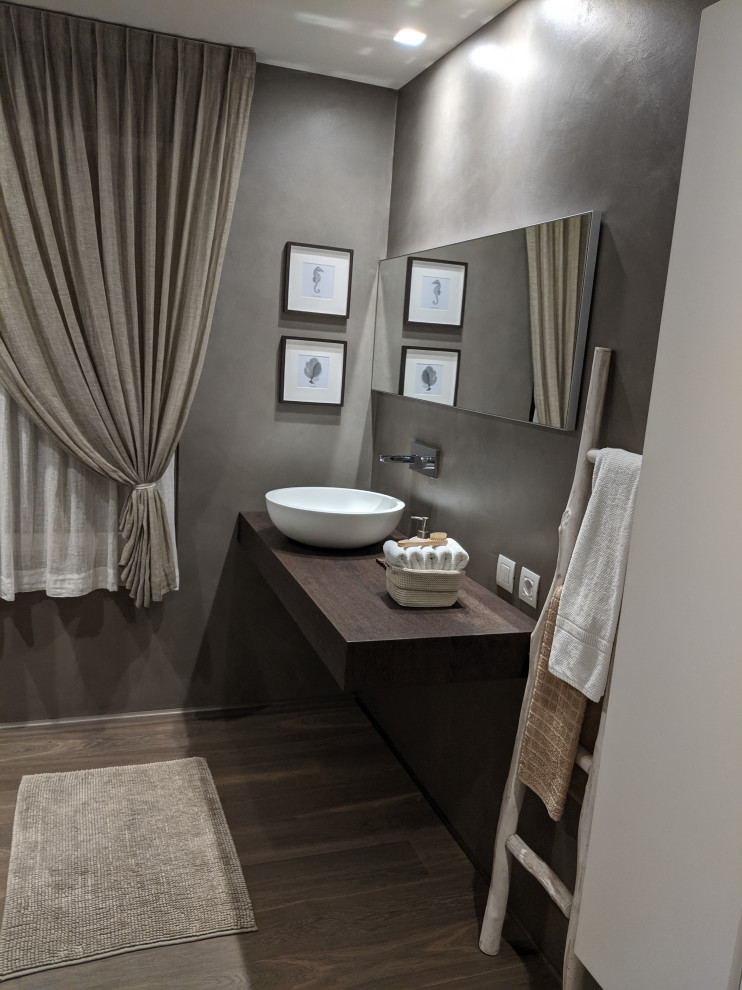 Inspiration för ett stort funkis brun brunt badrum med dusch, med släta luckor, vita skåp, en kantlös dusch, en vägghängd toalettstol, bruna väggar, mörkt trägolv, ett fristående handfat, träbänkskiva, brunt golv och med dusch som är öppen