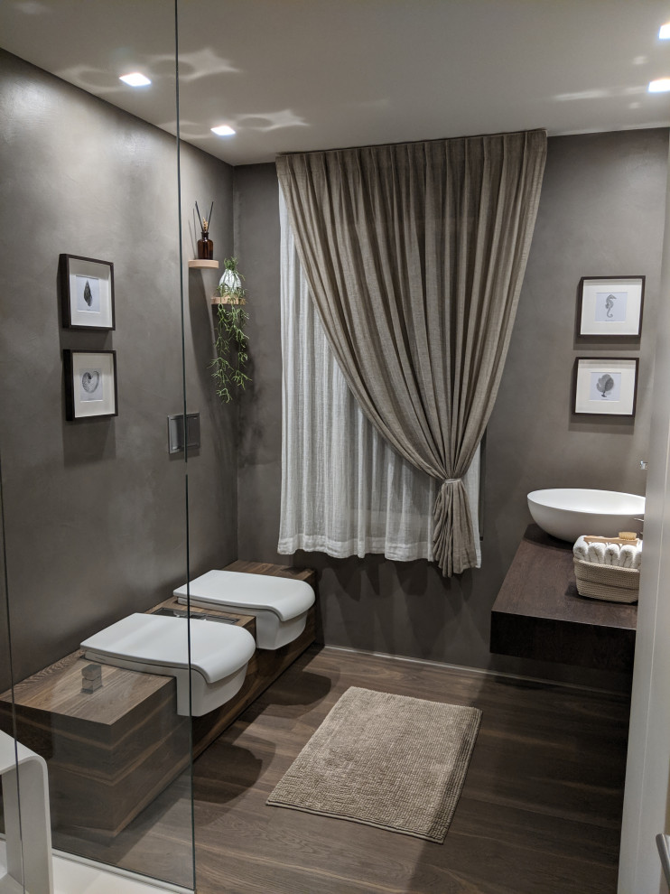 Idéer för stora funkis brunt badrum med dusch, med släta luckor, vita skåp, en kantlös dusch, en vägghängd toalettstol, bruna väggar, mörkt trägolv, ett fristående handfat, träbänkskiva, brunt golv och med dusch som är öppen