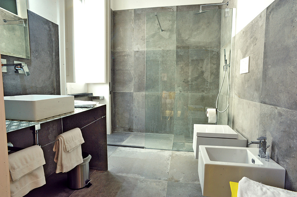 Inspiration för stora moderna badrum med dusch, med öppna hyllor, grå skåp, en kantlös dusch, grå kakel, porslinskakel, vita väggar, klinkergolv i porslin, ett avlångt handfat och bänkskiva i rostfritt stål