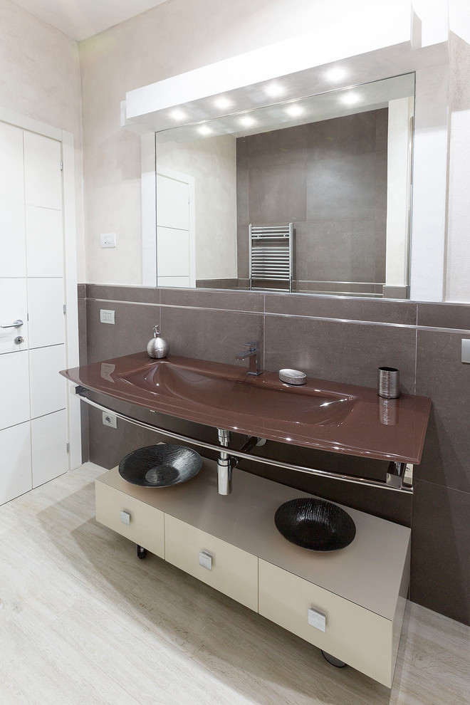 Modernes Badezimmer mit flächenbündigen Schrankfronten, beigen Schränken, braunen Fliesen und integriertem Waschbecken in Florenz