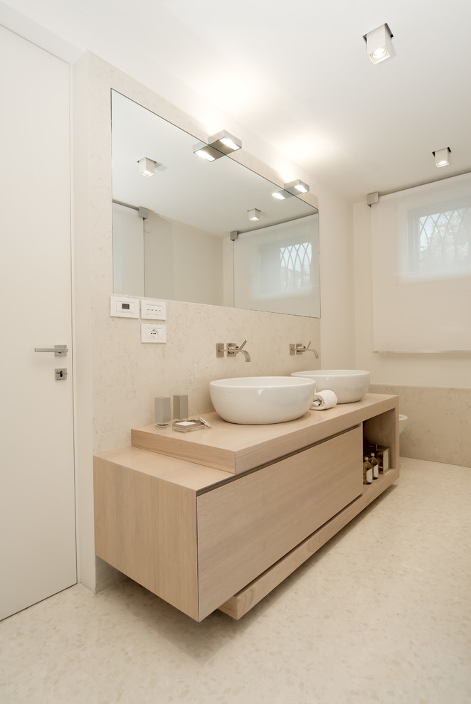 Источник вдохновения для домашнего уюта: ванная комната в современном стиле с настольной раковиной, плоскими фасадами, светлыми деревянными фасадами, столешницей из дерева, бежевой плиткой и бежевыми стенами