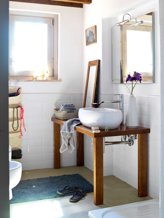 Cette photo montre une petite salle d'eau nature en bois brun avec un placard sans porte, une douche d'angle, WC séparés, un carrelage blanc, un carrelage métro, un mur blanc, sol en béton ciré, un plan de toilette en bois et une vasque.