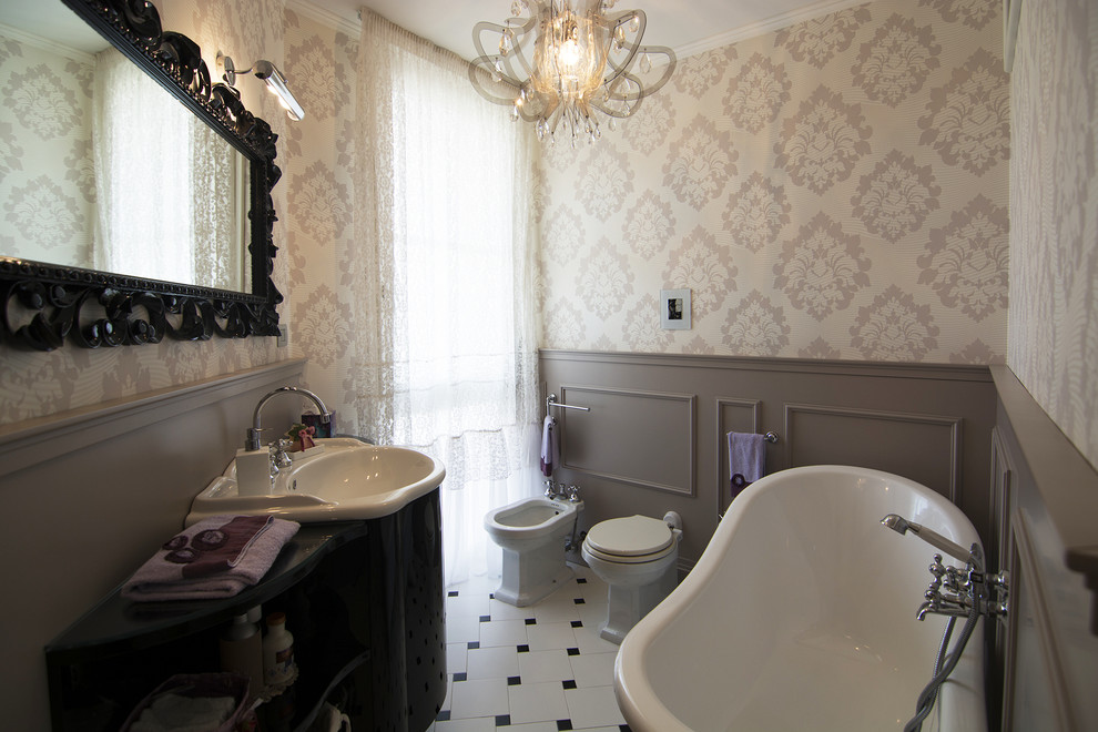 Modern inredning av ett litet badrum, med öppna hyllor, svarta skåp, klinkergolv i keramik, bänkskiva i glas, ett fristående badkar, en bidé, flerfärgade väggar och ett integrerad handfat