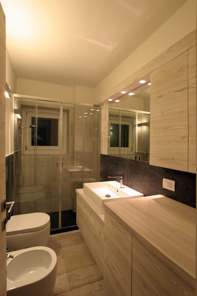 Bild på ett litet rustikt badrum med dusch, med släta luckor, skåp i ljust trä, en dusch i en alkov, en toalettstol med separat cisternkåpa, flerfärgade väggar, ljust trägolv, ett fristående handfat, flerfärgad kakel och porslinskakel