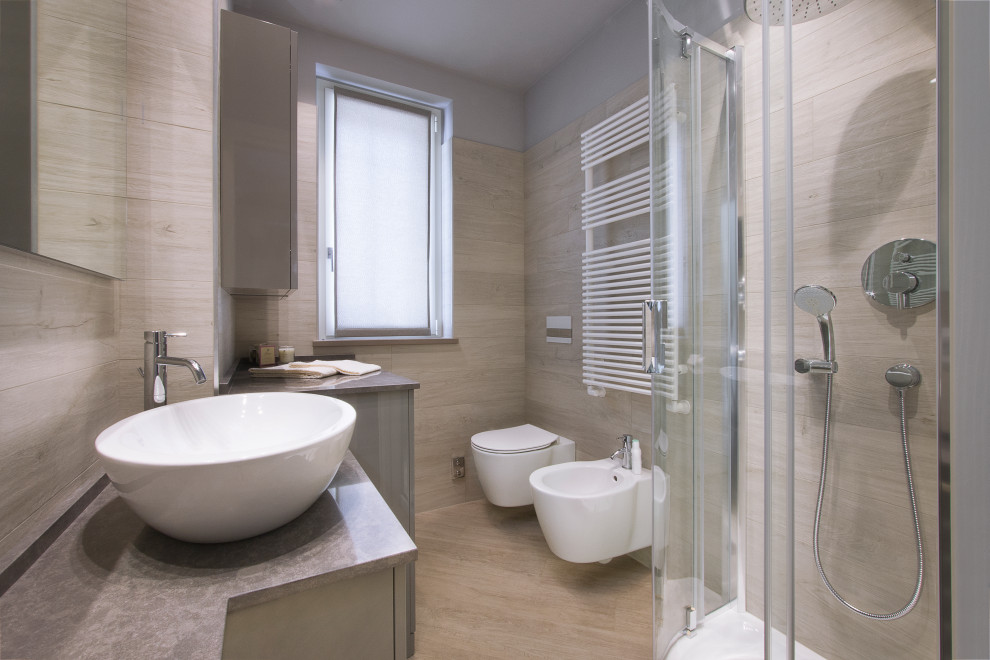 Источник вдохновения для домашнего уюта: ванная комната среднего размера в современном стиле с плоскими фасадами, серыми фасадами, угловым душем, инсталляцией, бежевой плиткой, керамогранитной плиткой, серыми стенами, полом из керамогранита, душевой кабиной, настольной раковиной, бежевым полом, душем с распашными дверями и серой столешницей