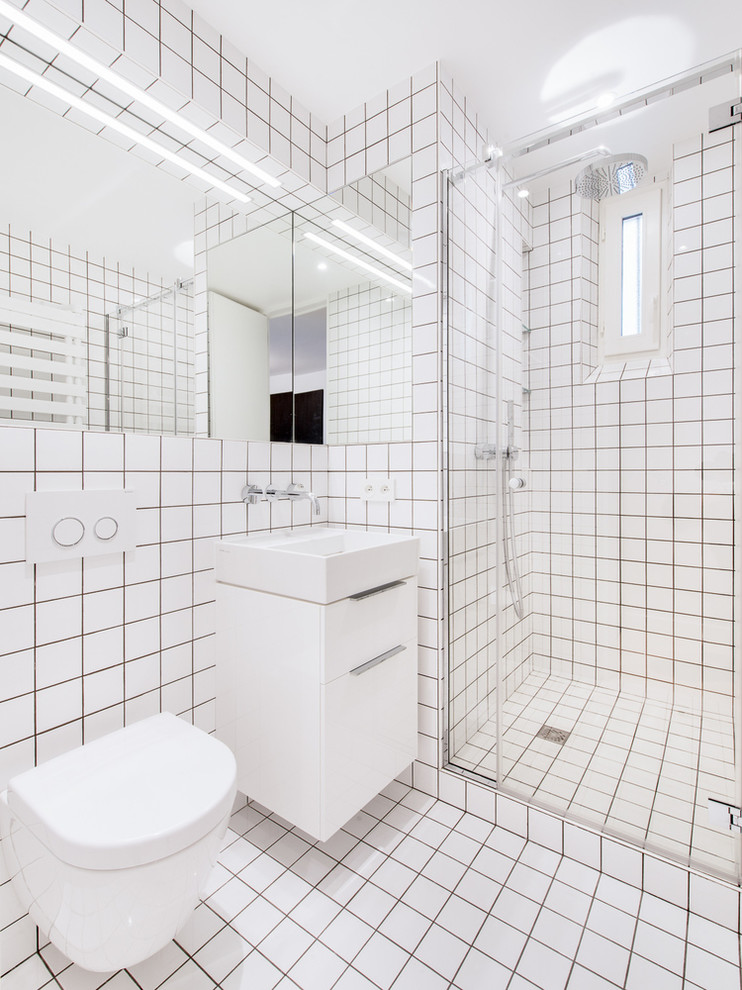 Foto di una stanza da bagno con doccia minimal con lavabo a consolle, ante lisce, ante bianche, doccia alcova, WC sospeso, piastrelle bianche e pareti bianche