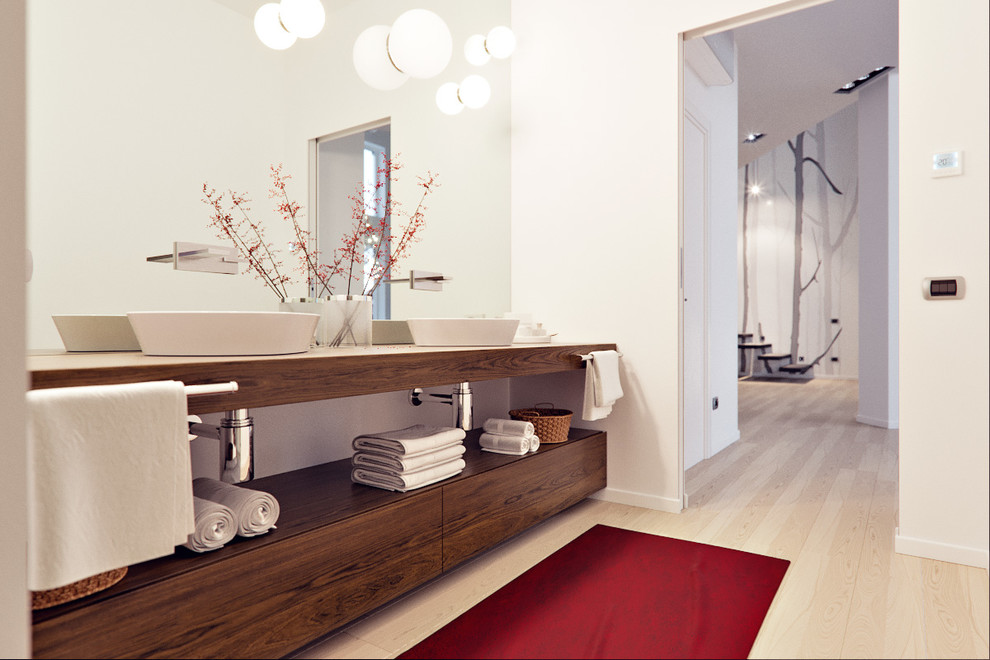 Modelo de cuarto de baño contemporáneo grande con puertas de armario de madera clara, ducha abierta, sanitario de pared, paredes multicolor, suelo de madera clara, aseo y ducha, lavabo sobreencimera y encimera de madera