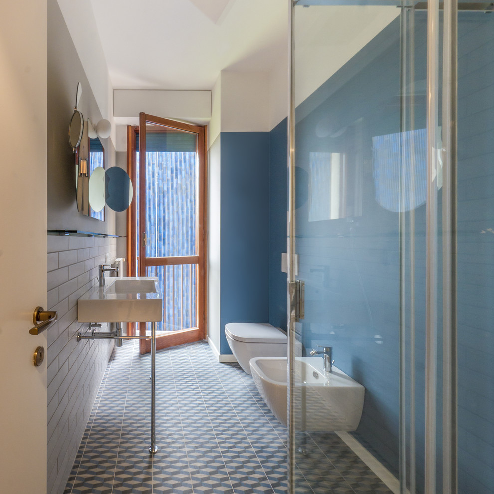 Design ideas for a small contemporary shower room bathroom in Milan with open cabinets, dark wood cabinets, a corner shower, a two-piece toilet, grey tiles, porcelain tiles, blue walls, porcelain flooring, a console sink, wooden worktops, multi-coloured floors and a sliding door.