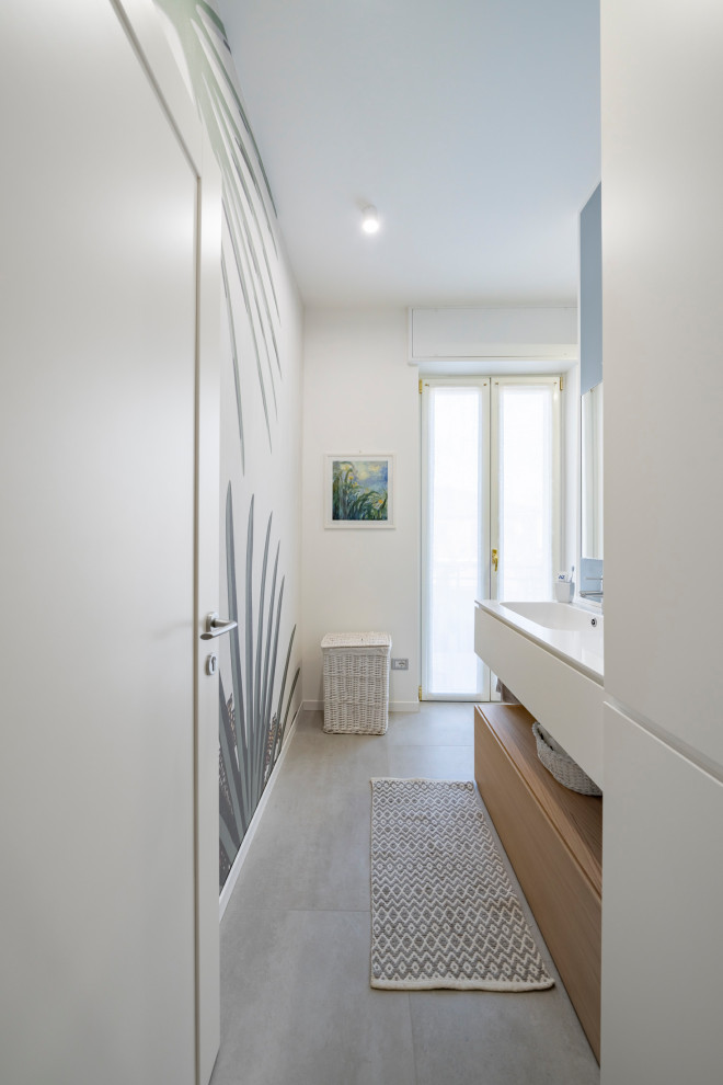 На фото: большая ванная комната в стиле модернизм с плоскими фасадами, белыми фасадами, душем в нише, раздельным унитазом, серой плиткой, керамогранитной плиткой, разноцветными стенами, полом из керамогранита, душевой кабиной, монолитной раковиной, столешницей из искусственного кварца, серым полом, душем с распашными дверями и белой столешницей