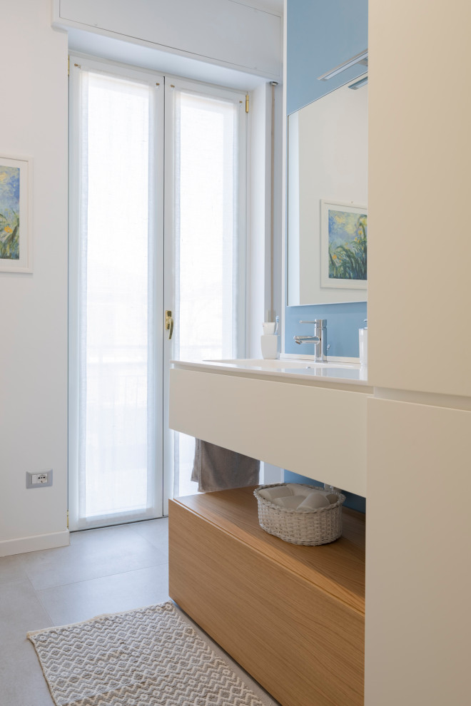 Пример оригинального дизайна: большая ванная комната в стиле модернизм с плоскими фасадами, белыми фасадами, душем в нише, раздельным унитазом, серой плиткой, керамогранитной плиткой, разноцветными стенами, полом из керамогранита, душевой кабиной, монолитной раковиной, столешницей из искусственного кварца, серым полом, душем с распашными дверями и белой столешницей