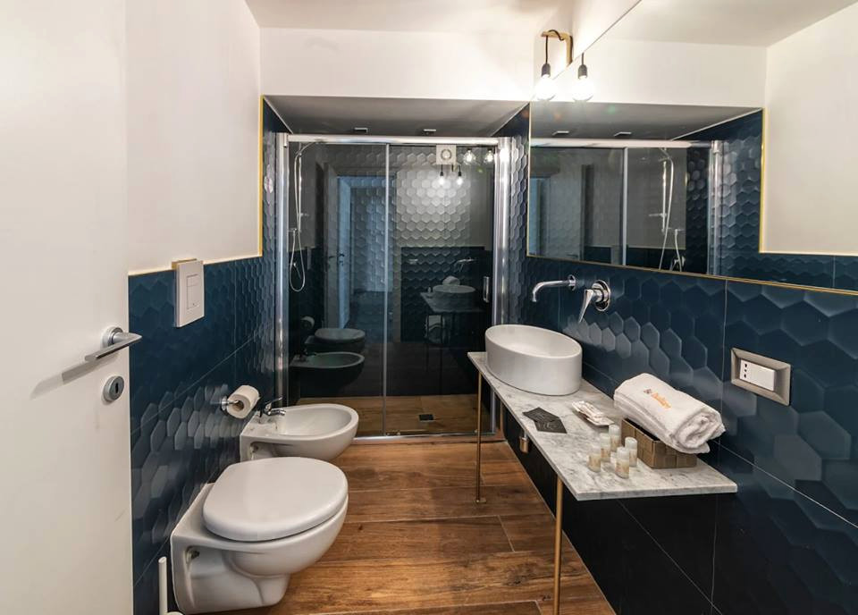 Inspiration för små eklektiska vitt badrum med dusch, med en kantlös dusch, en vägghängd toalettstol, blå kakel, porslinskakel, vita väggar, klinkergolv i porslin, ett fristående handfat, marmorbänkskiva, brunt golv och dusch med skjutdörr