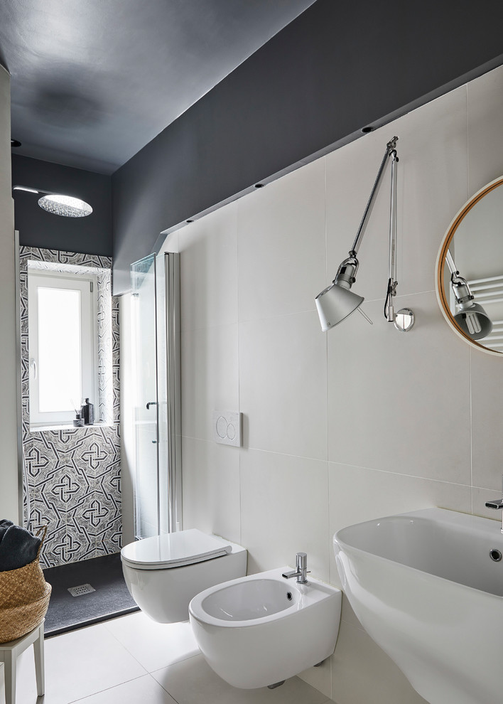 Exemple d'une salle de bain tendance de taille moyenne avec WC suspendus, un carrelage noir et blanc, des carreaux de porcelaine, un mur noir, un sol en carrelage de porcelaine, un lavabo suspendu, un sol blanc et une cabine de douche à porte battante.