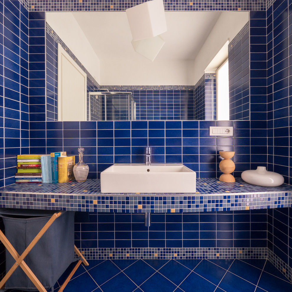 Esempio di una piccola e in muratura stanza da bagno con doccia minimal con doccia ad angolo, WC a due pezzi, piastrelle blu, piastrelle a mosaico, pareti blu, pavimento con piastrelle in ceramica, lavabo rettangolare, top in cemento, pavimento blu e porta doccia scorrevole