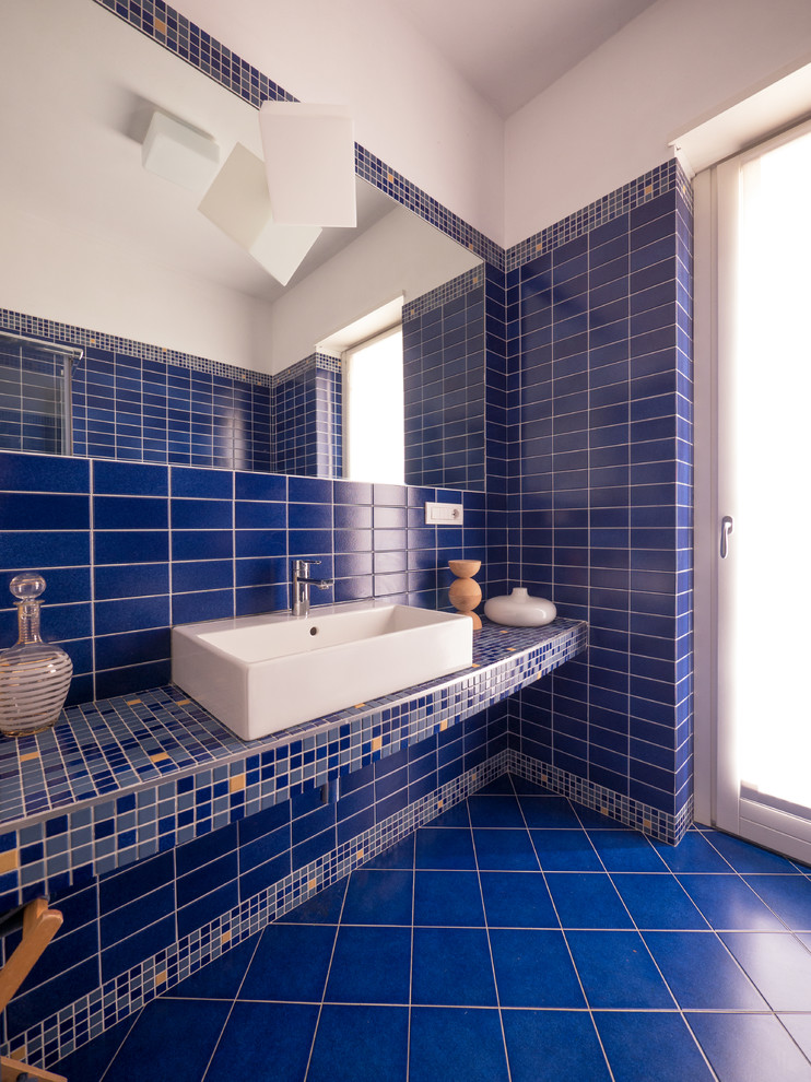 Esempio di una piccola e in muratura stanza da bagno con doccia contemporanea con doccia ad angolo, WC a due pezzi, piastrelle blu, piastrelle a mosaico, pareti blu, pavimento con piastrelle in ceramica, lavabo rettangolare, top in cemento, pavimento blu e porta doccia scorrevole