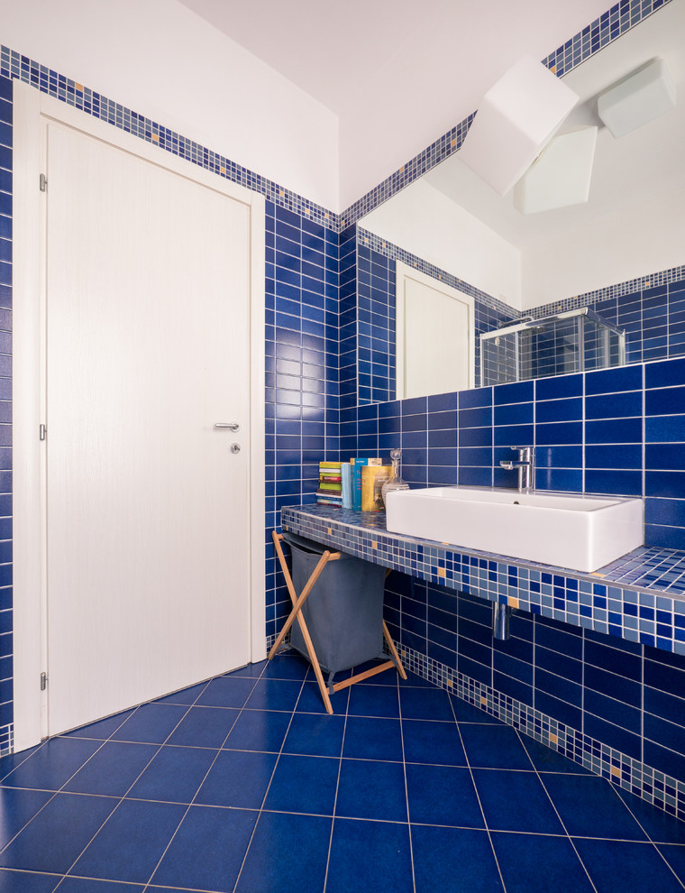 Kleines Modernes Duschbad mit Eckdusche, Wandtoilette mit Spülkasten, blauen Fliesen, Mosaikfliesen, blauer Wandfarbe, Keramikboden, Trogwaschbecken, Beton-Waschbecken/Waschtisch, blauem Boden und Schiebetür-Duschabtrennung in Mailand