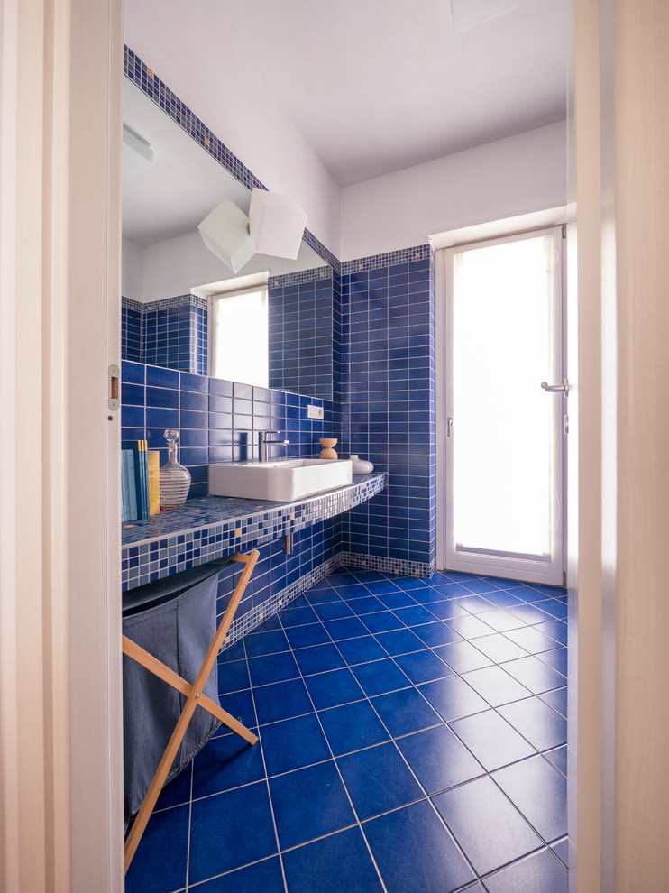 Esempio di una piccola e in muratura stanza da bagno con doccia contemporanea con doccia ad angolo, WC a due pezzi, piastrelle blu, piastrelle a mosaico, pareti blu, pavimento con piastrelle in ceramica, lavabo rettangolare, top in cemento, pavimento blu e porta doccia scorrevole