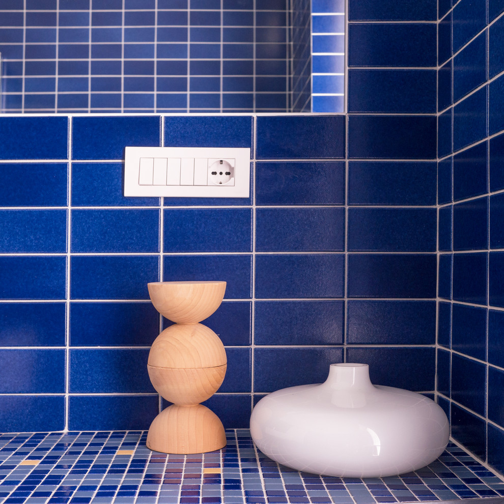 ミラノにある高級な小さなコンテンポラリースタイルのおしゃれなバスルーム (浴槽なし) (コーナー設置型シャワー、分離型トイレ、青いタイル、モザイクタイル、青い壁、セラミックタイルの床、横長型シンク、コンクリートの洗面台、青い床、引戸のシャワー) の写真