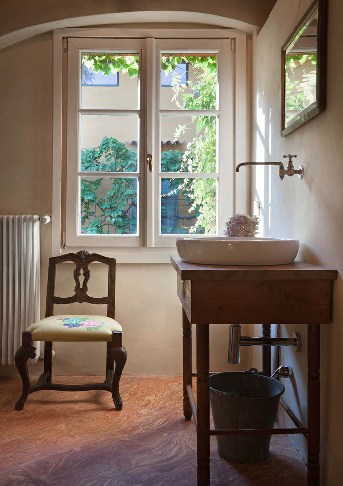 Réalisation d'une grande douche en alcôve principale champêtre en bois foncé avec un placard à porte shaker, un sol en brique, une vasque, un plan de toilette en bois, un carrelage beige, un mur beige et un sol rouge.