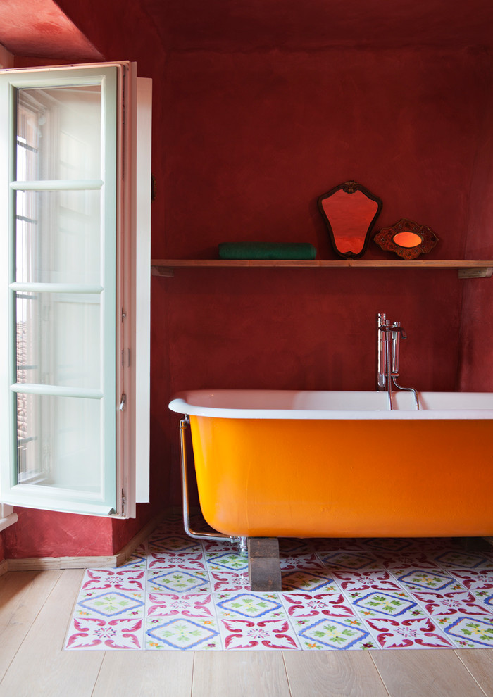 Idéer för mellanstora lantliga en-suite badrum, med en dusch i en alkov, ett fristående handfat, träbänkskiva, luckor med profilerade fronter, skåp i ljust trä, ett fristående badkar, röda väggar, cementgolv och flerfärgat golv