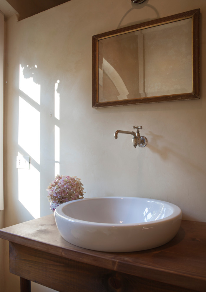 На фото: главная ванная комната среднего размера в стиле кантри с фасадами в стиле шейкер, душем в нише, кирпичным полом, настольной раковиной, столешницей из дерева, темными деревянными фасадами и бежевыми стенами