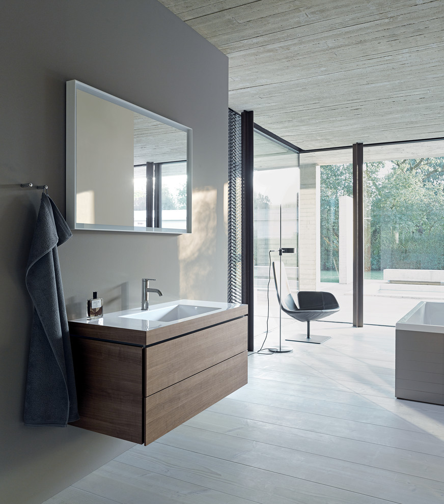 Idee per una stanza da bagno design di medie dimensioni con ante in legno chiaro e lavabo a consolle