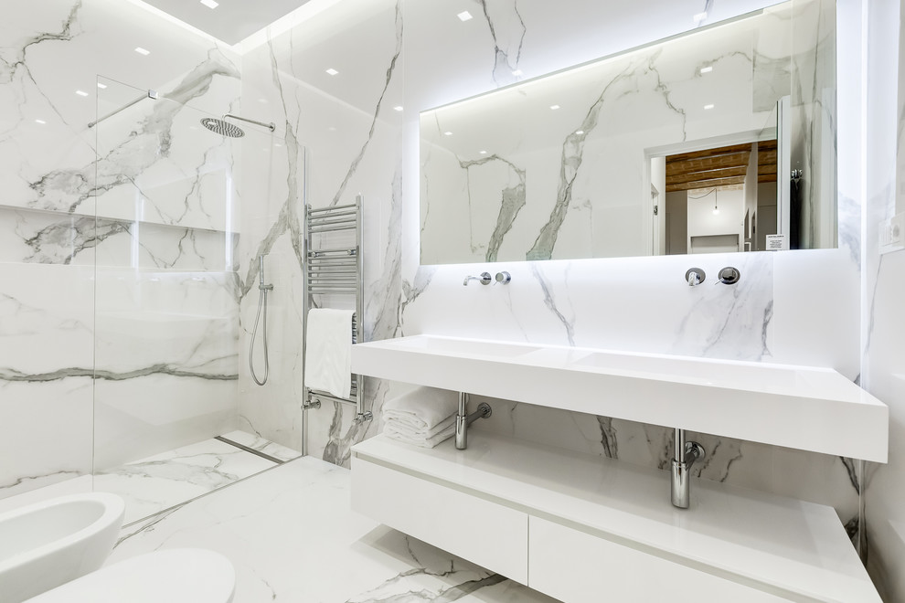 Aménagement d'une salle de bain contemporaine avec un placard sans porte, des portes de placard blanches, un mur gris, un sol en marbre, un lavabo intégré, un sol gris, une cabine de douche à porte battante et un plan de toilette blanc.