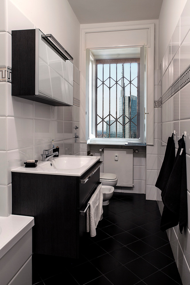 Imagen de cuarto de baño clásico con armarios con paneles lisos, puertas de armario negras, baldosas y/o azulejos blancos, baldosas y/o azulejos de cerámica y lavabo integrado